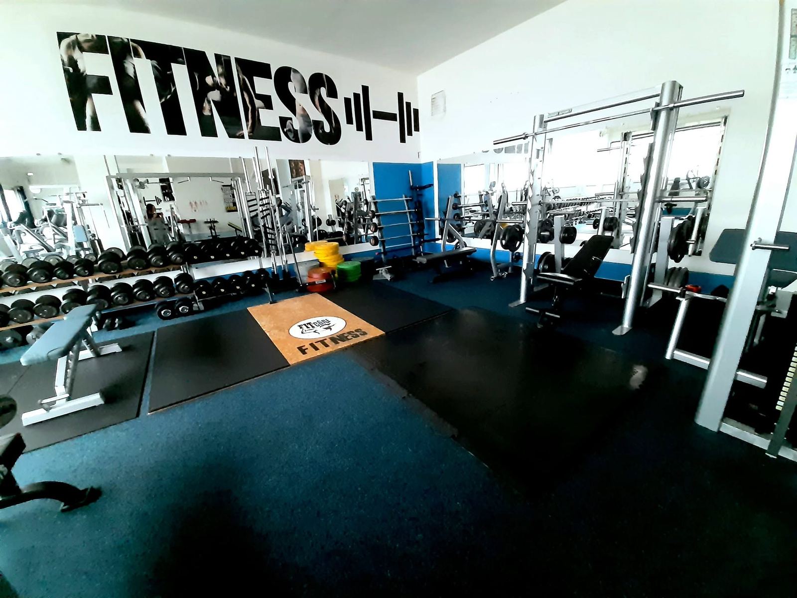 Posilovna Fitcore Fitness s volnými činkami a stroji